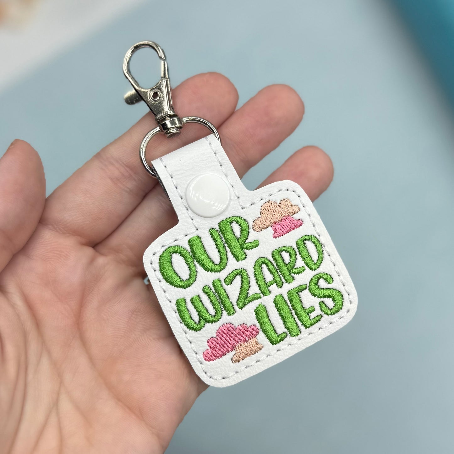 Our Wizard Lies pink clouds keychain